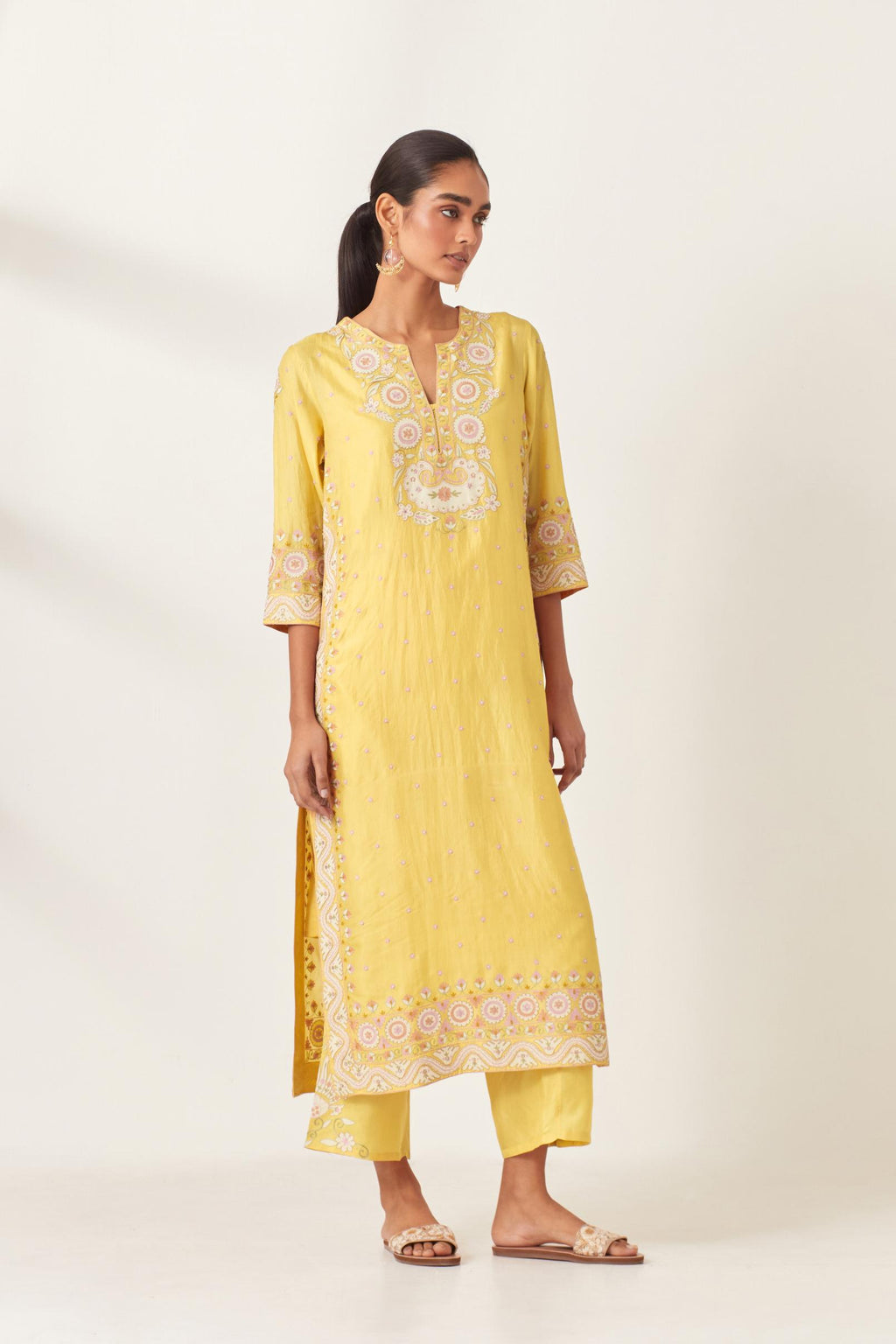 Yellow slim fit straight kurta set, decorated with bold appliqué borders all along the side seam, hem and sleeve cuffs.