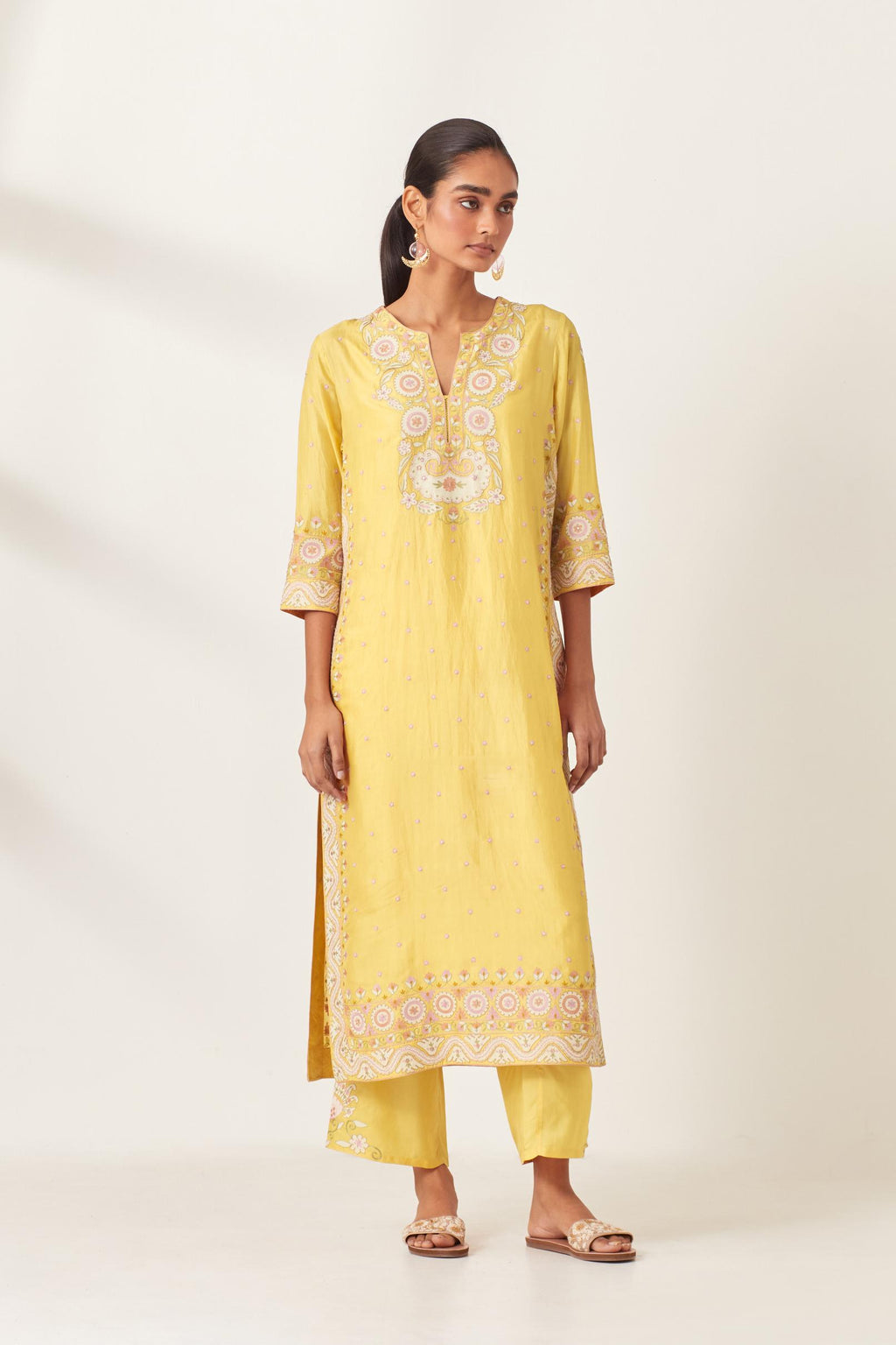 Yellow slim fit straight kurta set, decorated with bold appliqué borders all along the side seam, hem and sleeve cuffs.