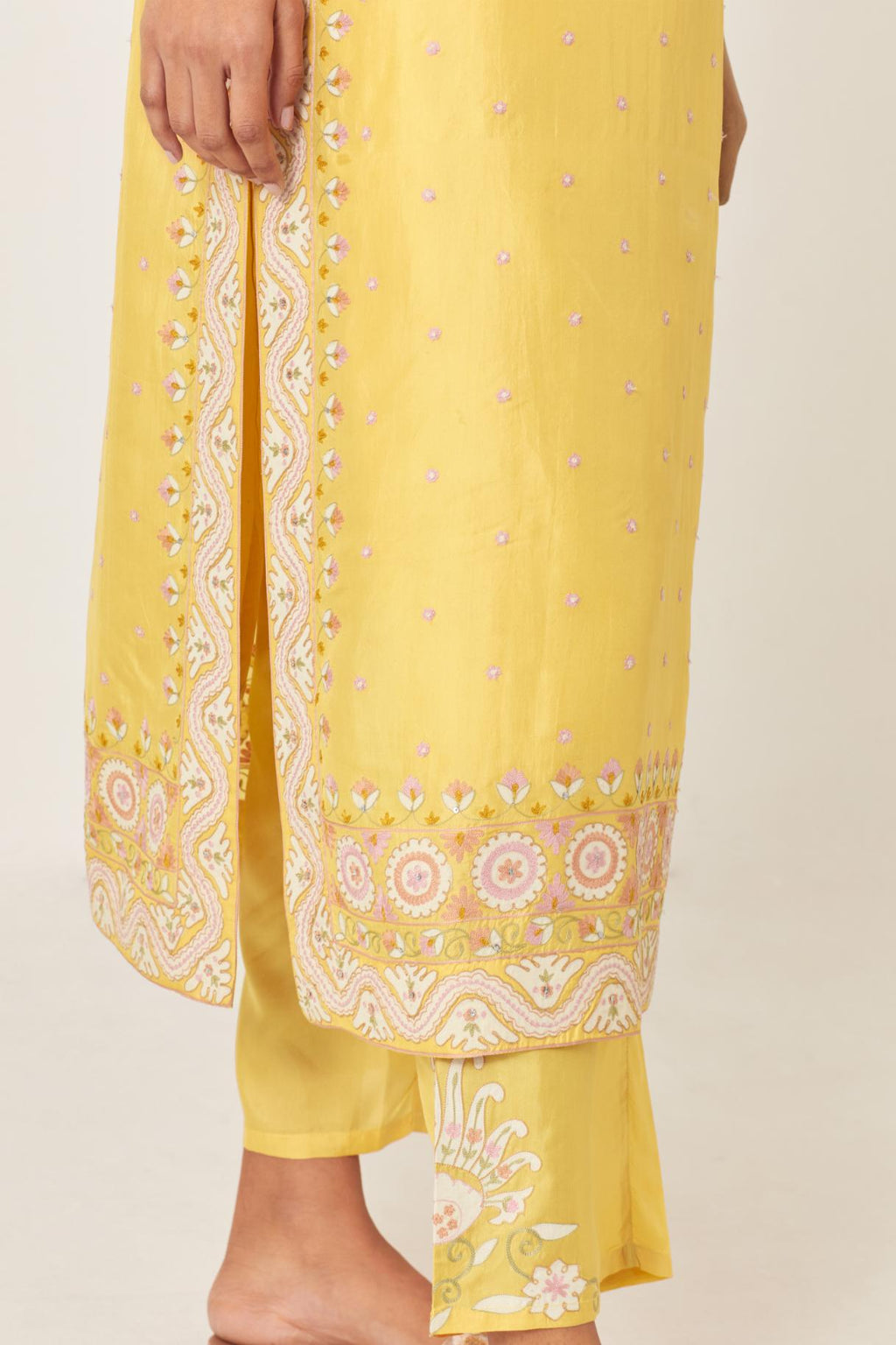 Yellow slim fit straight kurta set, decorated with bold appliqué borders all along the side seam, hem and sleeve cuffs.