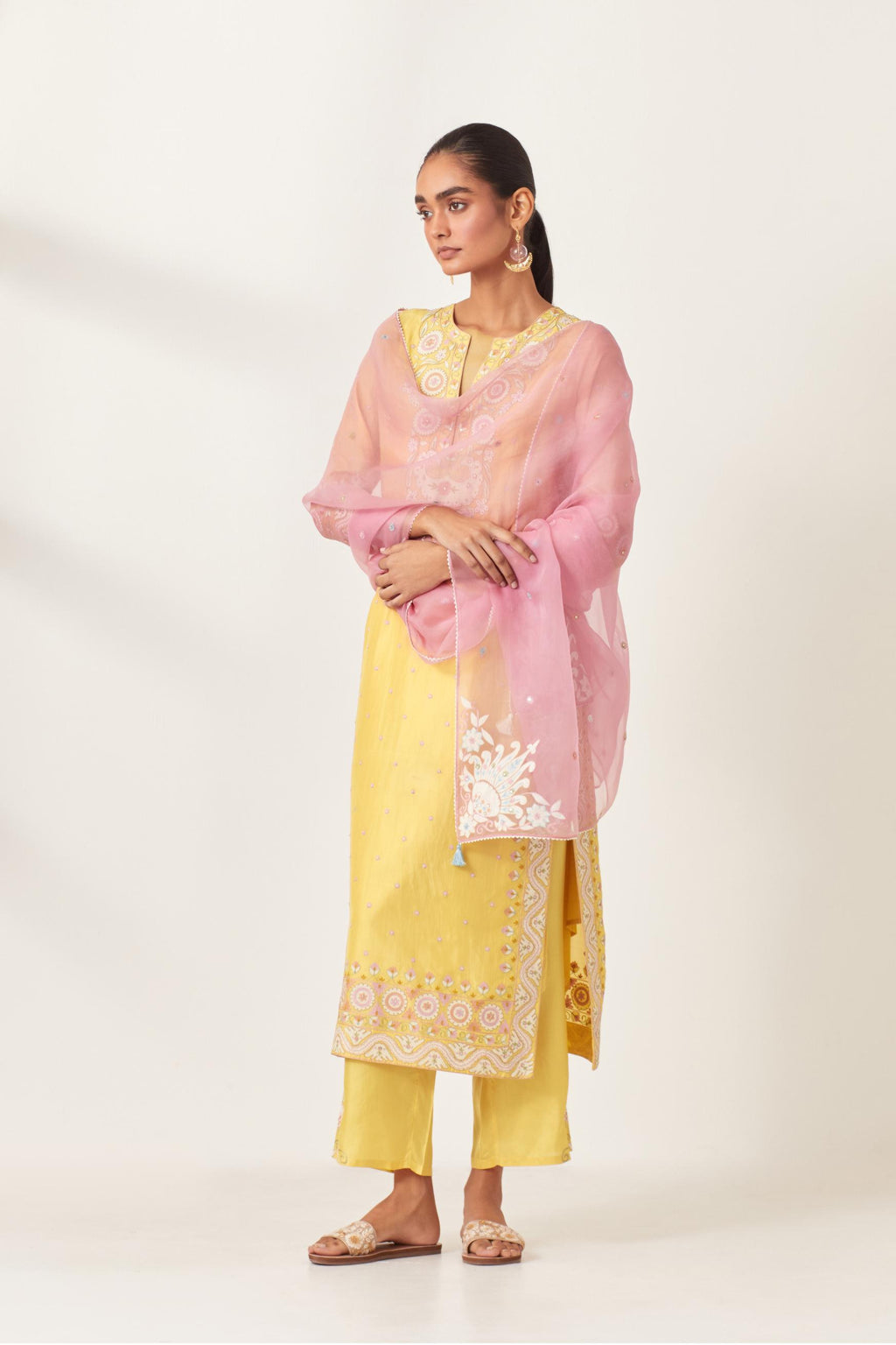 Yellow slim fit straight kurta set, decorated with bold appliqué borders all along the side seam, hem and sleeve cuffs.