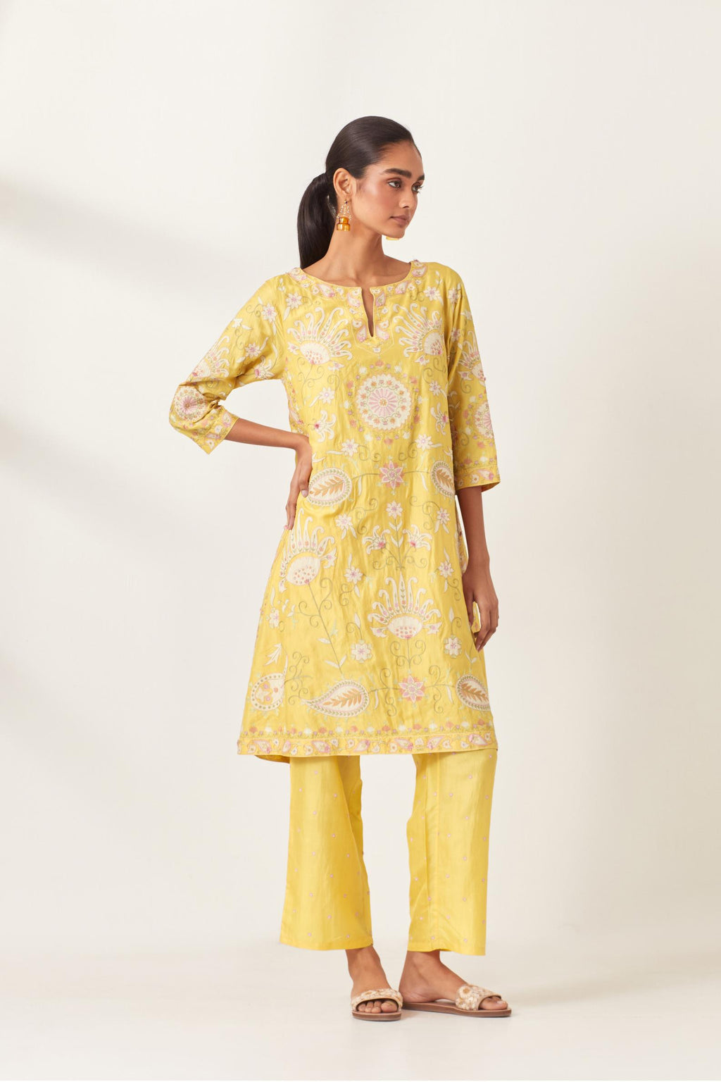 Yellow short A-line silk kurta set, fully embroidered with multi colored appliqué with aari thread work and silk tassels.