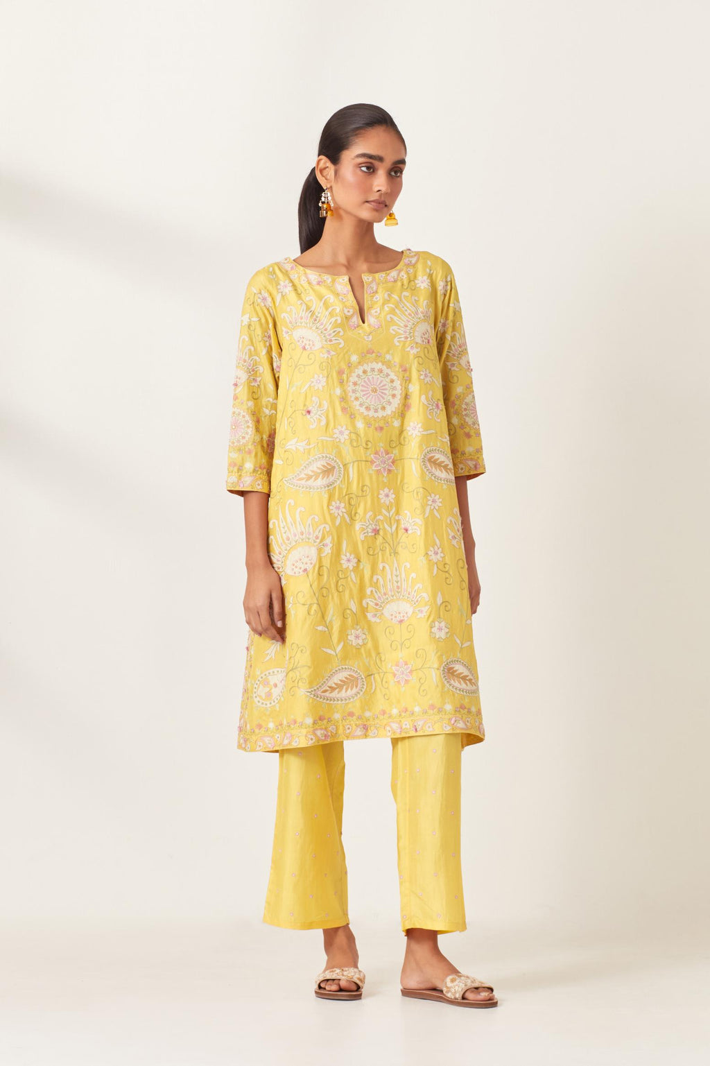 Yellow short A-line silk kurta set, fully embroidered with multi colored appliqué with aari thread work and silk tassels.