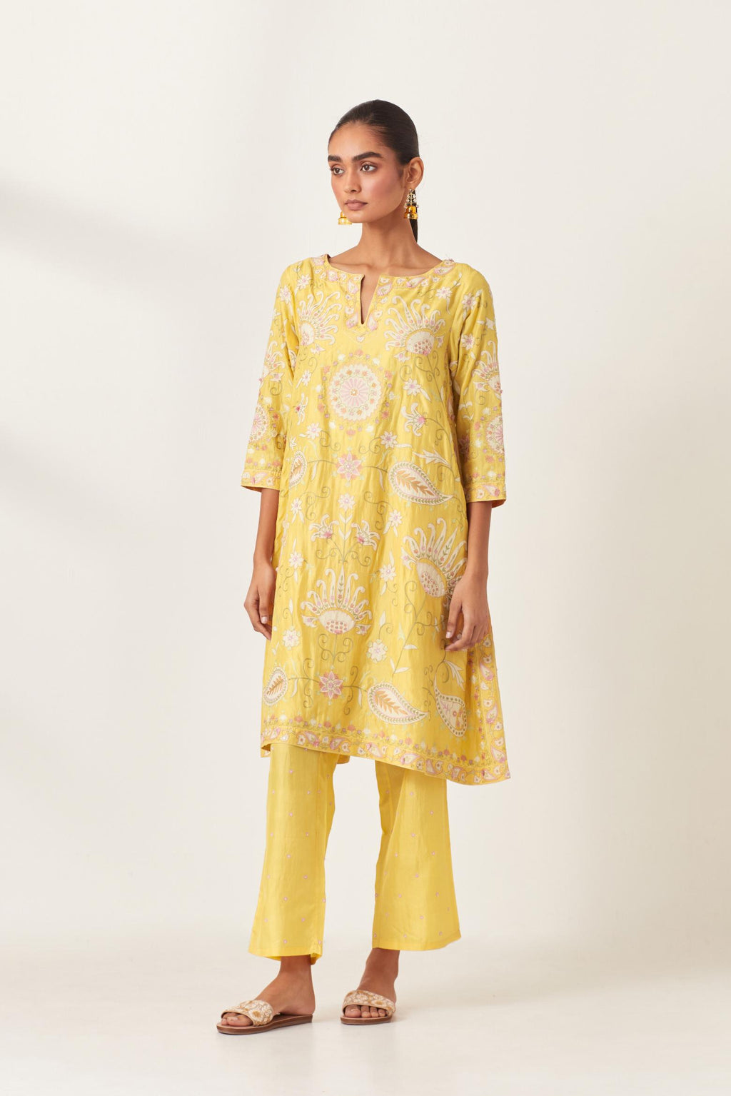 Yellow short A-line silk kurta set, fully embroidered with multi colored appliqué with aari thread work and silk tassels.