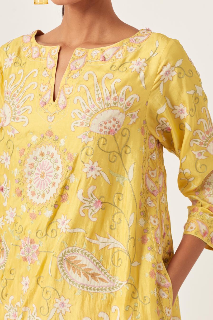 Yellow short A-line silk kurta set, fully embroidered with multi colored appliqué with aari thread work and silk tassels.