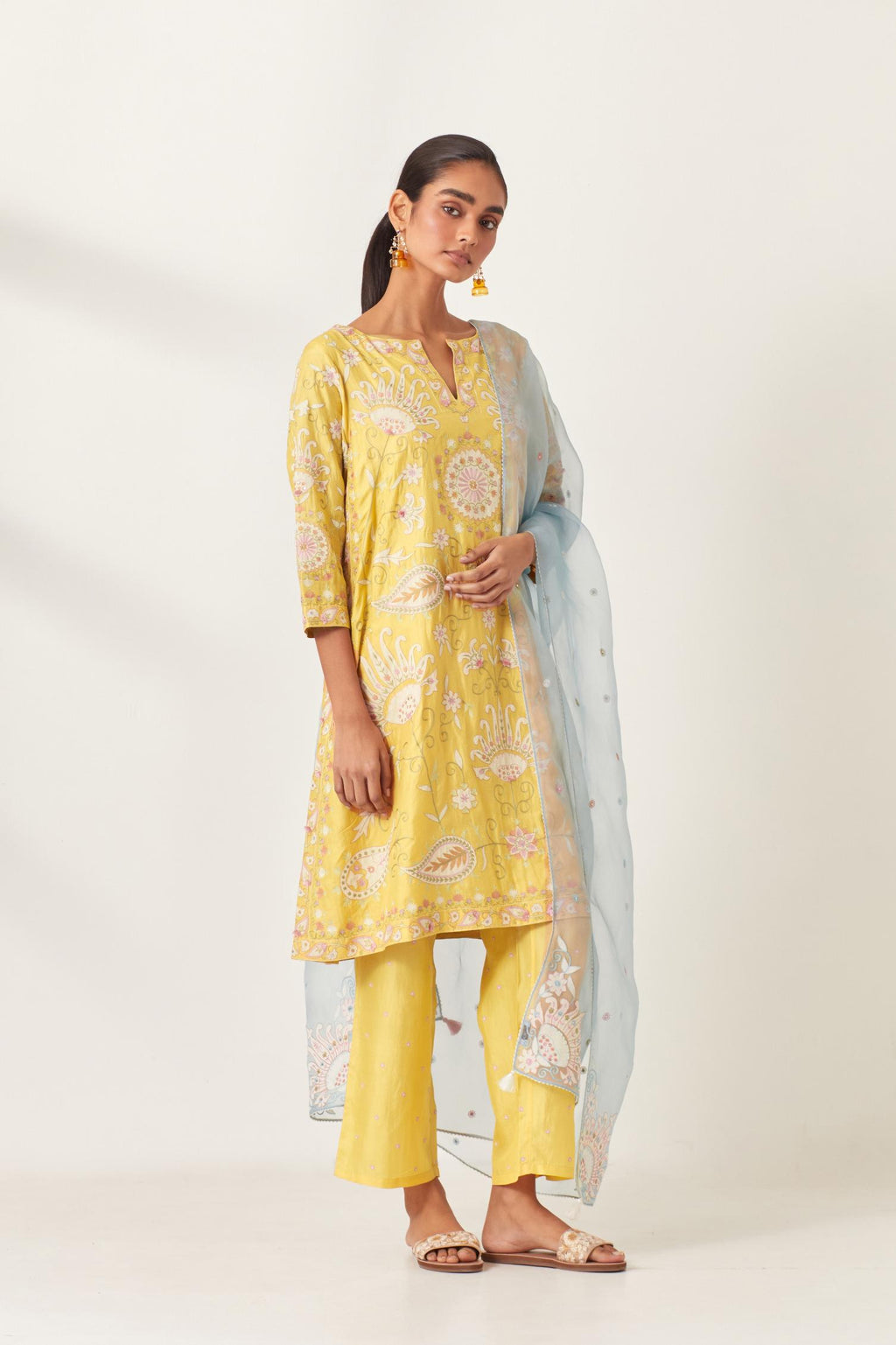 Yellow short A-line silk kurta set, fully embroidered with multi colored appliqué with aari thread work and silk tassels.