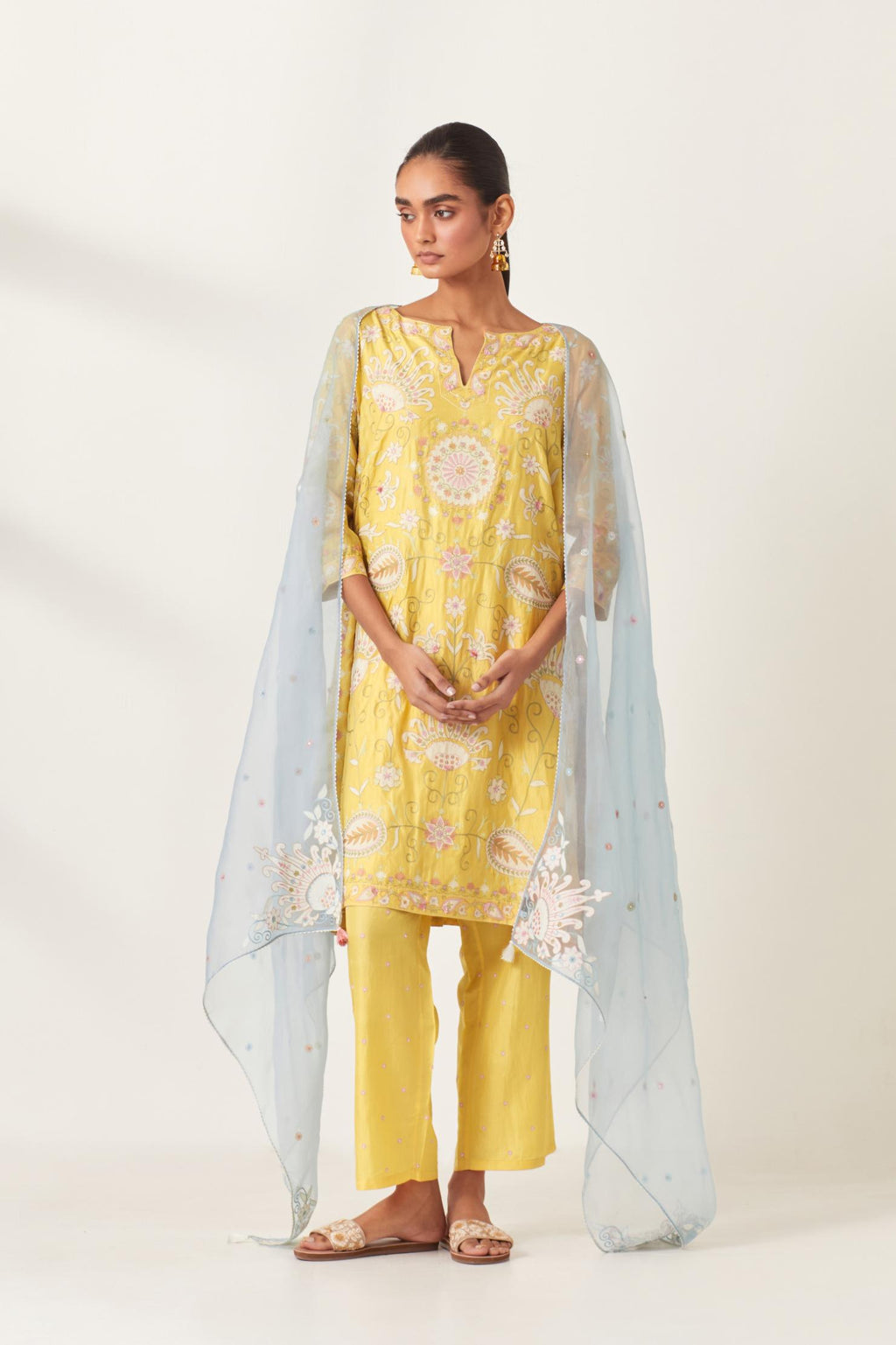 Yellow short A-line silk kurta set, fully embroidered with multi colored appliqué with aari thread work and silk tassels.