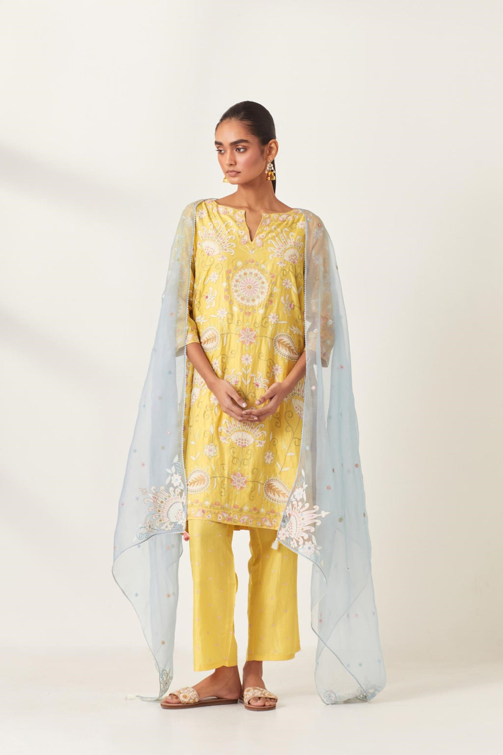 Yellow short A-line silk kurta set, fully embroidered with multi colored appliqué with aari thread work and silk tassels.