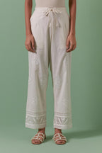 Off white cotton straight pants with all over off white silk thread embroidery detailed with sequins.
