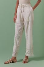 Off white cotton straight pants with all over off white silk thread embroidery detailed with sequins.