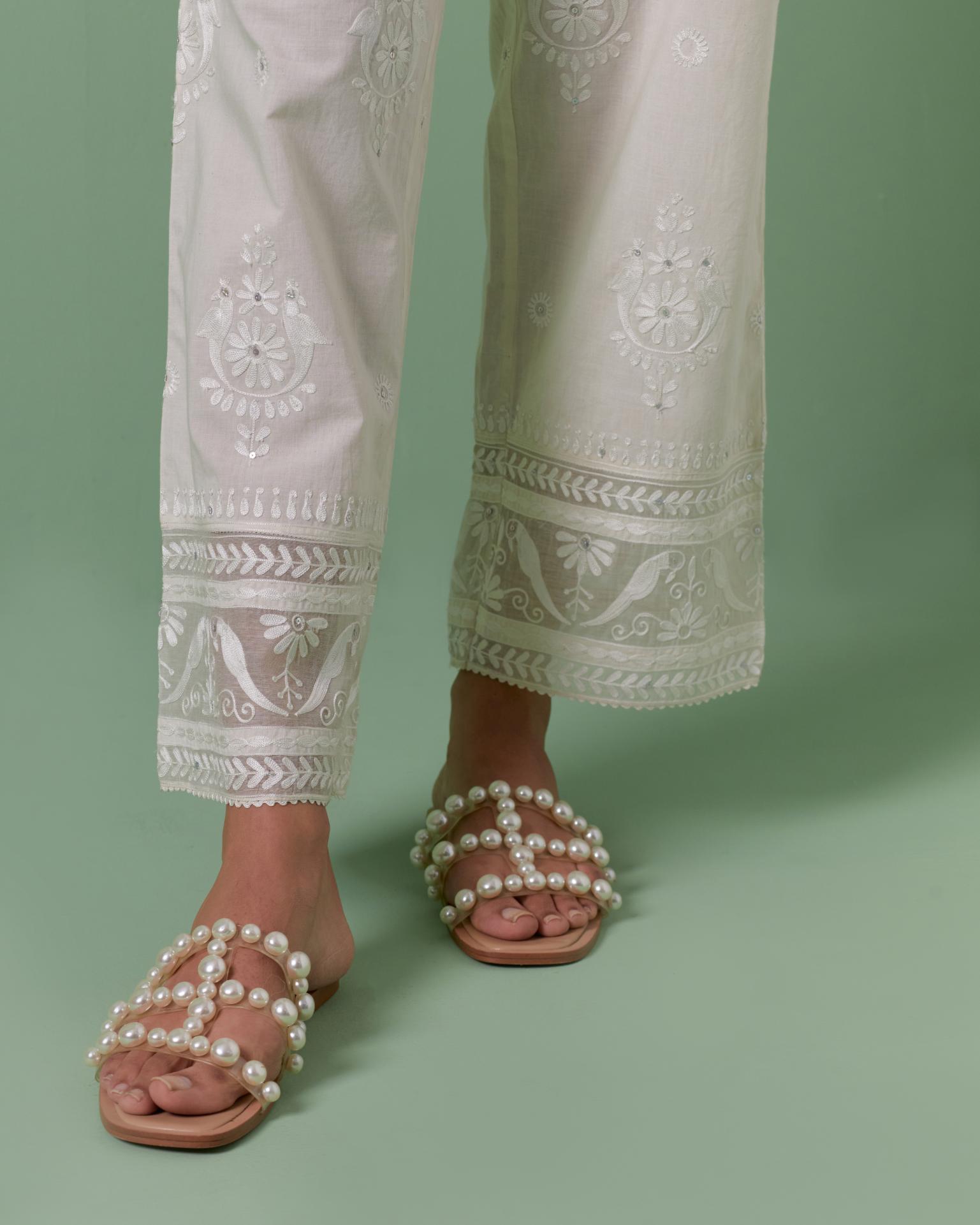 Off white cotton straight pants with all over off white silk thread embroidery detailed with sequins.