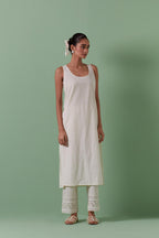 Off-white cotton chanderi easy fit long kaftan detailed with patch, silk thread, mirror & sequins work, paired with off white cotton straight pants with all over off white silk thread embroidery detailed with sequins.