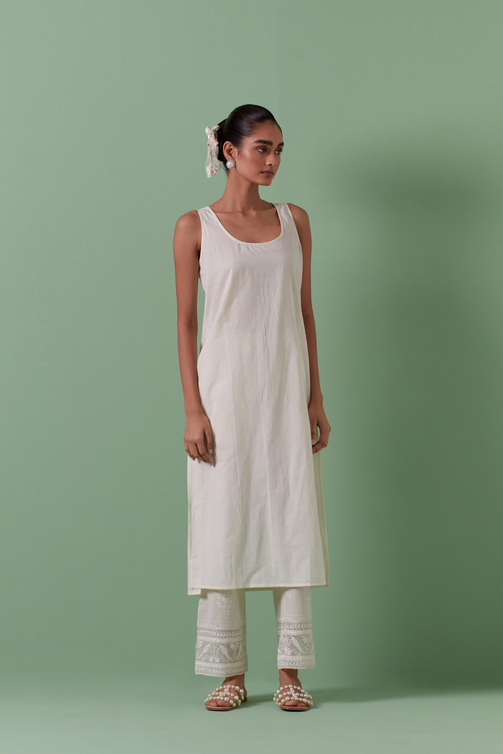 Off-white cotton chanderi easy fit long kaftan detailed with patch, silk thread, mirror & sequins work, paired with off white cotton straight pants with all over off white silk thread embroidery detailed with sequins.