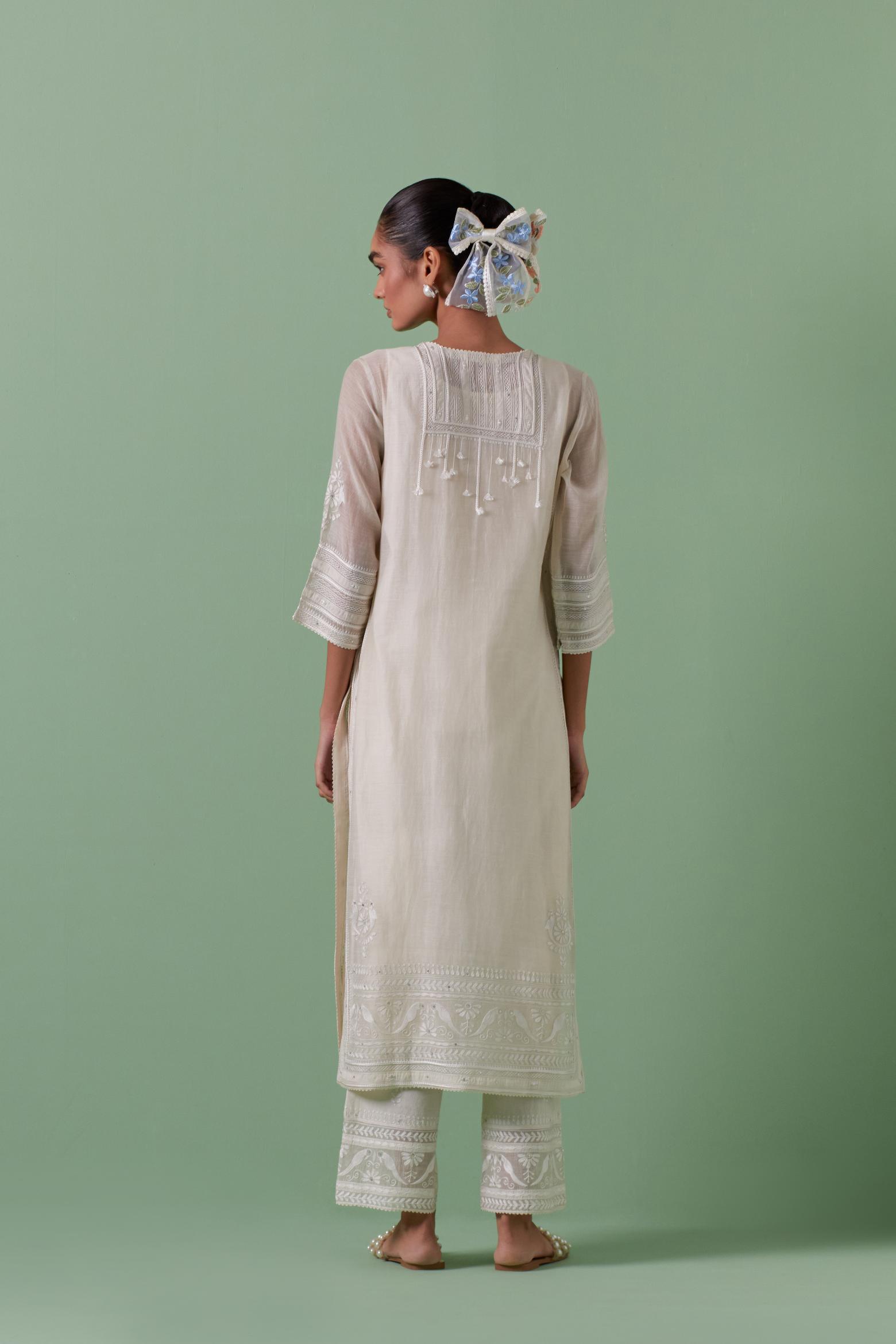 Off-white cotton chanderi straight kurta set with yoke with patchwork and silk thread embroidery highlighted with mirror, sequins, tassels and braids.