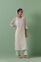 Off-white cotton chanderi straight kurta set with yoke with patchwork and silk thread embroidery highlighted with mirror, sequins, tassels and braids.