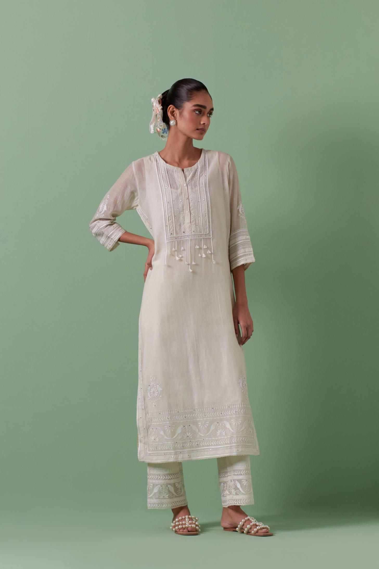 Off-white cotton chanderi straight kurta set with yoke with patchwork and silk thread embroidery highlighted with mirror, sequins, tassels and braids.