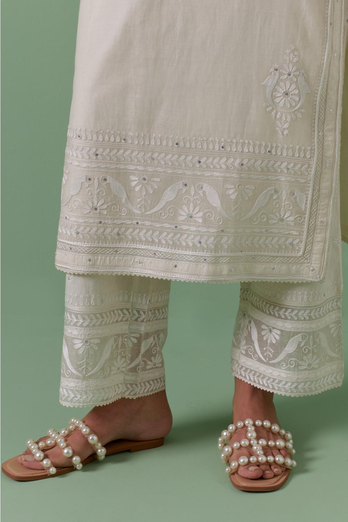 Off-white cotton chanderi straight kurta set with yoke with patchwork and silk thread embroidery highlighted with mirror, sequins, tassels and braids.