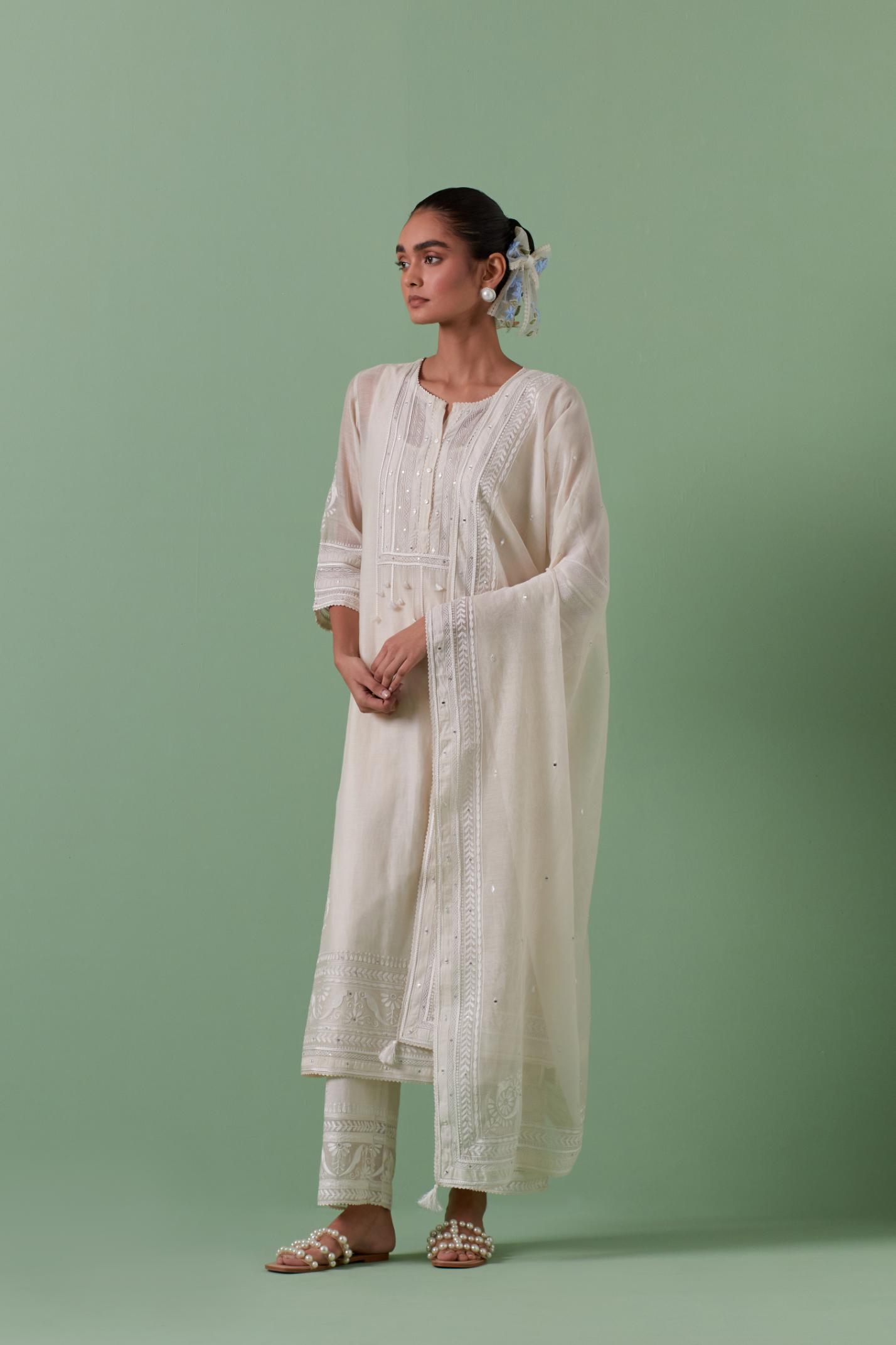 Off-white cotton chanderi straight kurta set with yoke with patchwork and silk thread embroidery highlighted with mirror, sequins, tassels and braids.