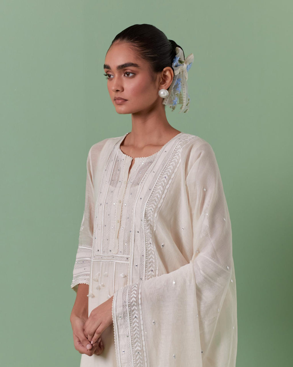 Off-white cotton chanderi dupatta with delicate silk thread embroidery, highlighted with braids, mirrors and sequins.