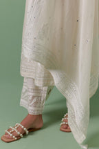 Off-white cotton chanderi straight kurta set with yoke with patchwork and silk thread embroidery highlighted with mirror, sequins, tassels and braids.