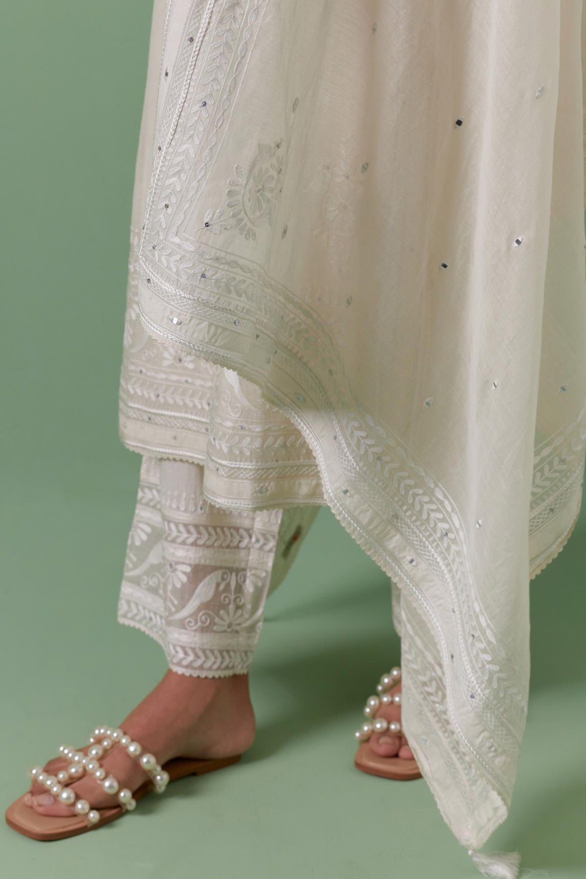 Off-white cotton chanderi straight kurta set with yoke with patchwork and silk thread embroidery highlighted with mirror, sequins, tassels and braids.