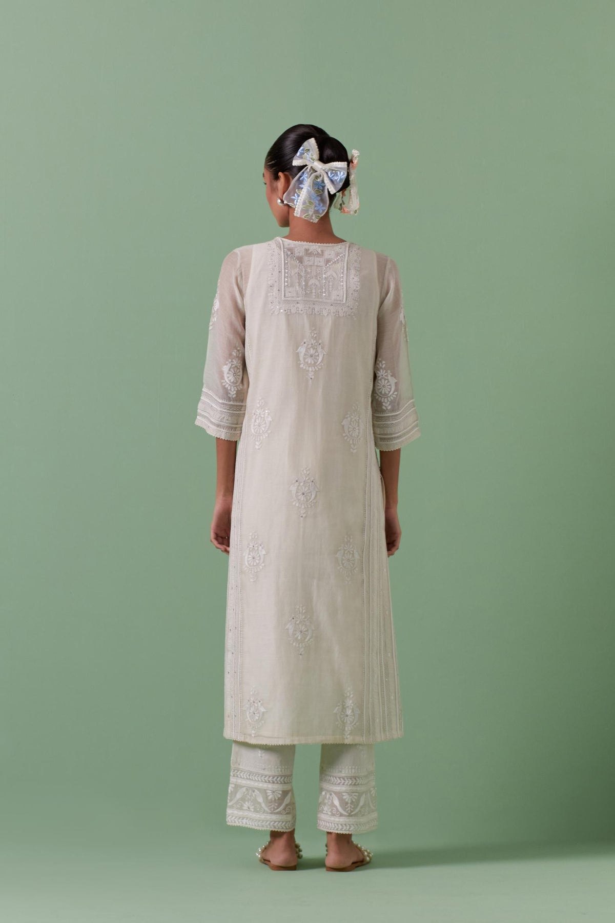 Off-white cotton chanderi straight kurta set with yoke and side panels. It has allover patchwork and silk thread embroidery, highlighted with mirror, sequins, tassels and braids.