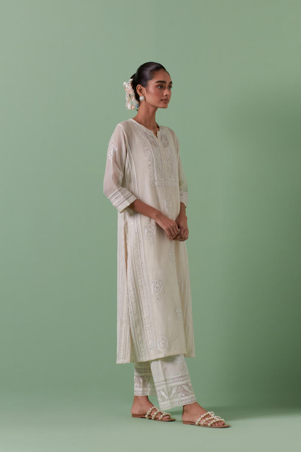 Off-white cotton chanderi straight kurta set with yoke and side panels. It has allover patchwork and silk thread embroidery, highlighted with mirror, sequins, tassels and braids.