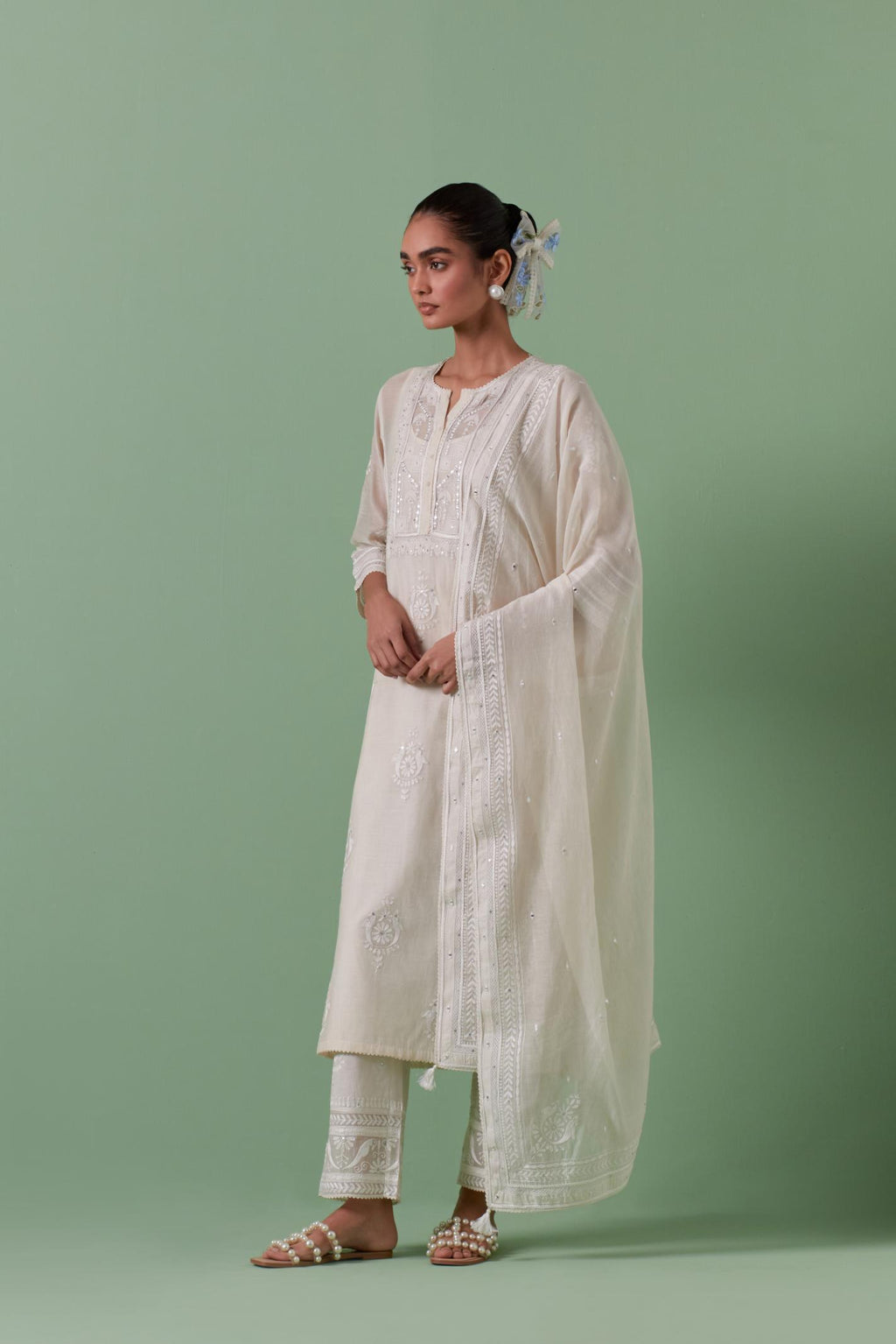 Off-white cotton chanderi straight kurta set with yoke and side panels. It has allover patchwork and silk thread embroidery, highlighted with mirror, sequins, tassels and braids.