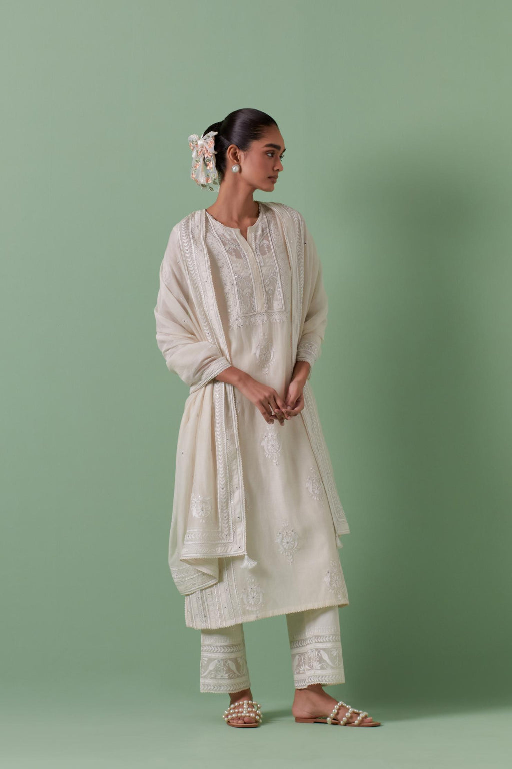 Off-white cotton chanderi straight kurta set with yoke and side panels. It has allover patchwork and silk thread embroidery, highlighted with mirror, sequins, tassels and braids.