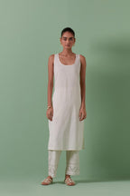 Off-white cotton chanderi straight kurta set with yoke and side panels. It has allover patchwork and silk thread embroidery, highlighted with mirror, sequins, tassels and braids.