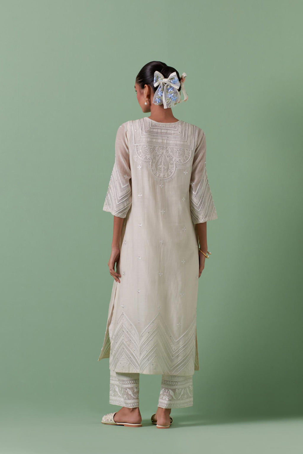 Off-white cotton chanderi straight kurta set with patchwork and thread embroidery highlighted with mirrors, sequins, tassels and braids.
