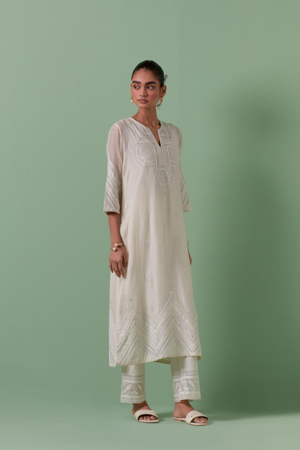Off-white cotton chanderi straight kurta set with patchwork and thread embroidery highlighted with mirrors, sequins, tassels and braids.