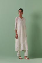 Off-white cotton chanderi straight kurta set with patchwork and thread embroidery highlighted with mirrors, sequins, tassels and braids.