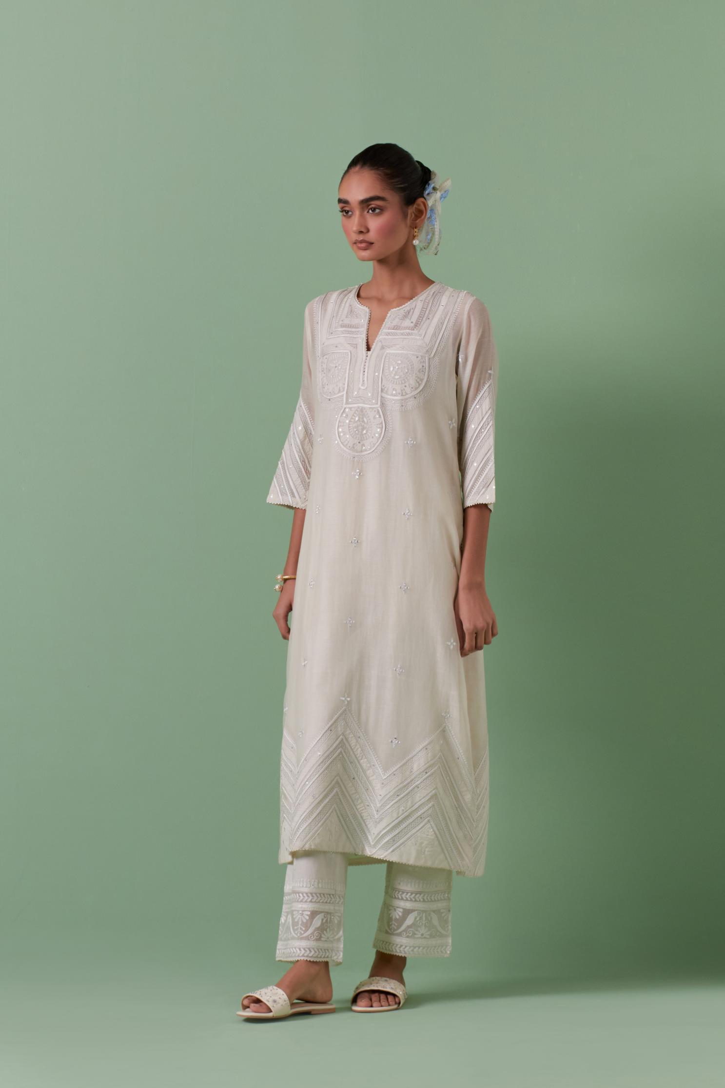 Off-white cotton chanderi straight kurta set with patchwork and thread embroidery highlighted with mirrors, sequins, tassels and braids.