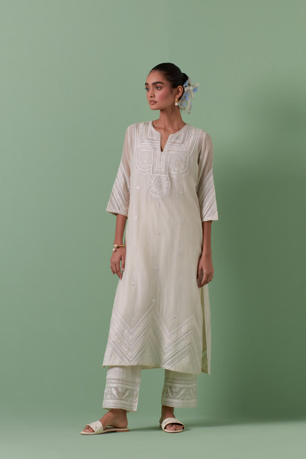 Off-white cotton chanderi straight kurta set with patchwork and thread embroidery highlighted with mirrors, sequins, tassels and braids.