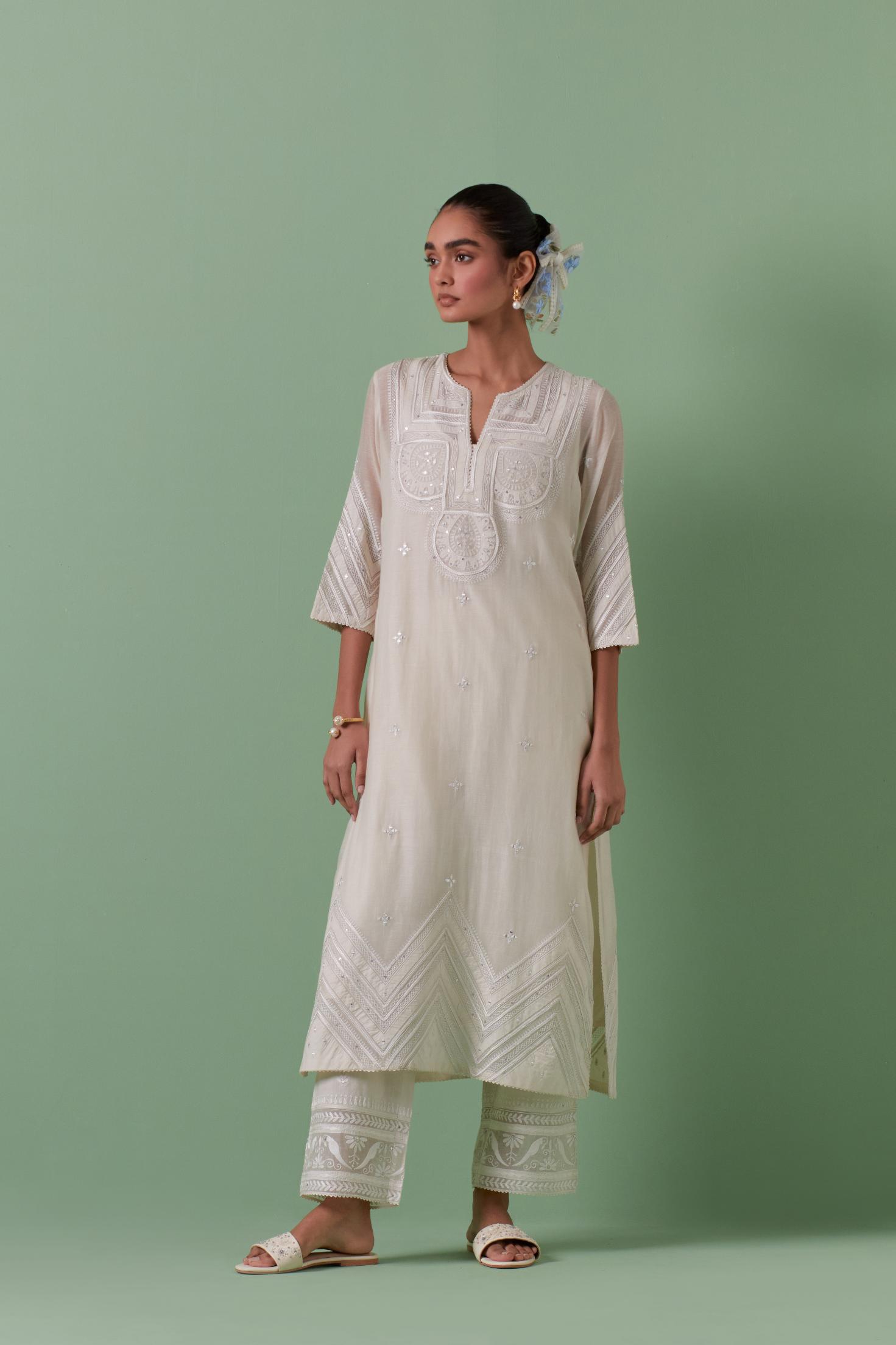 Off-white cotton chanderi straight kurta set with patchwork and thread embroidery highlighted with mirrors, sequins, tassels and braids.