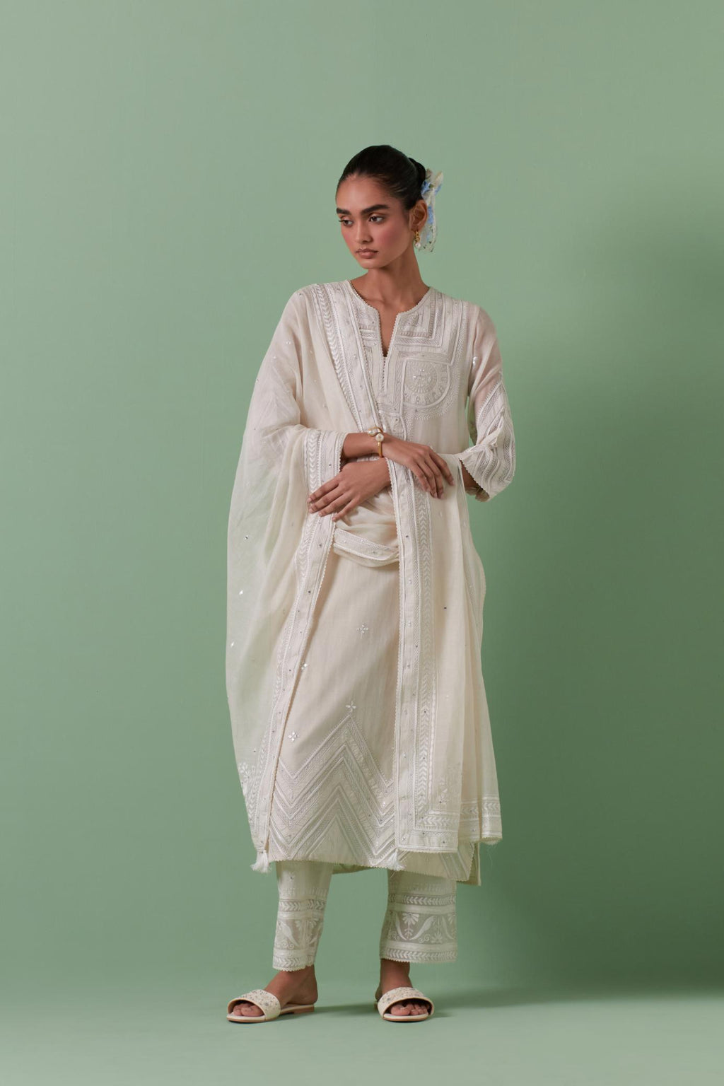 Off-white cotton chanderi straight kurta set with patchwork and thread embroidery highlighted with mirrors, sequins, tassels and braids.