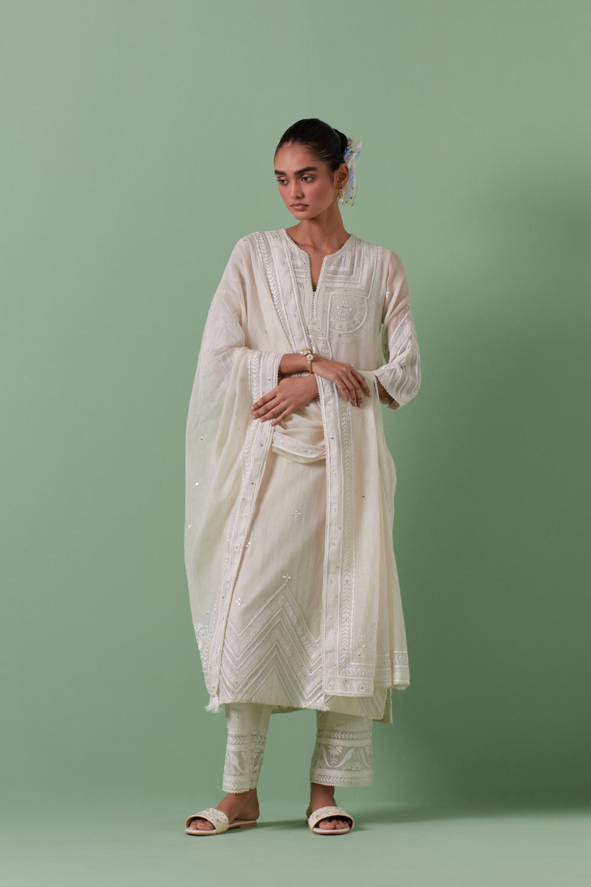 Off-white cotton chanderi straight kurta set with patchwork and thread embroidery highlighted with mirrors, sequins, tassels and braids.