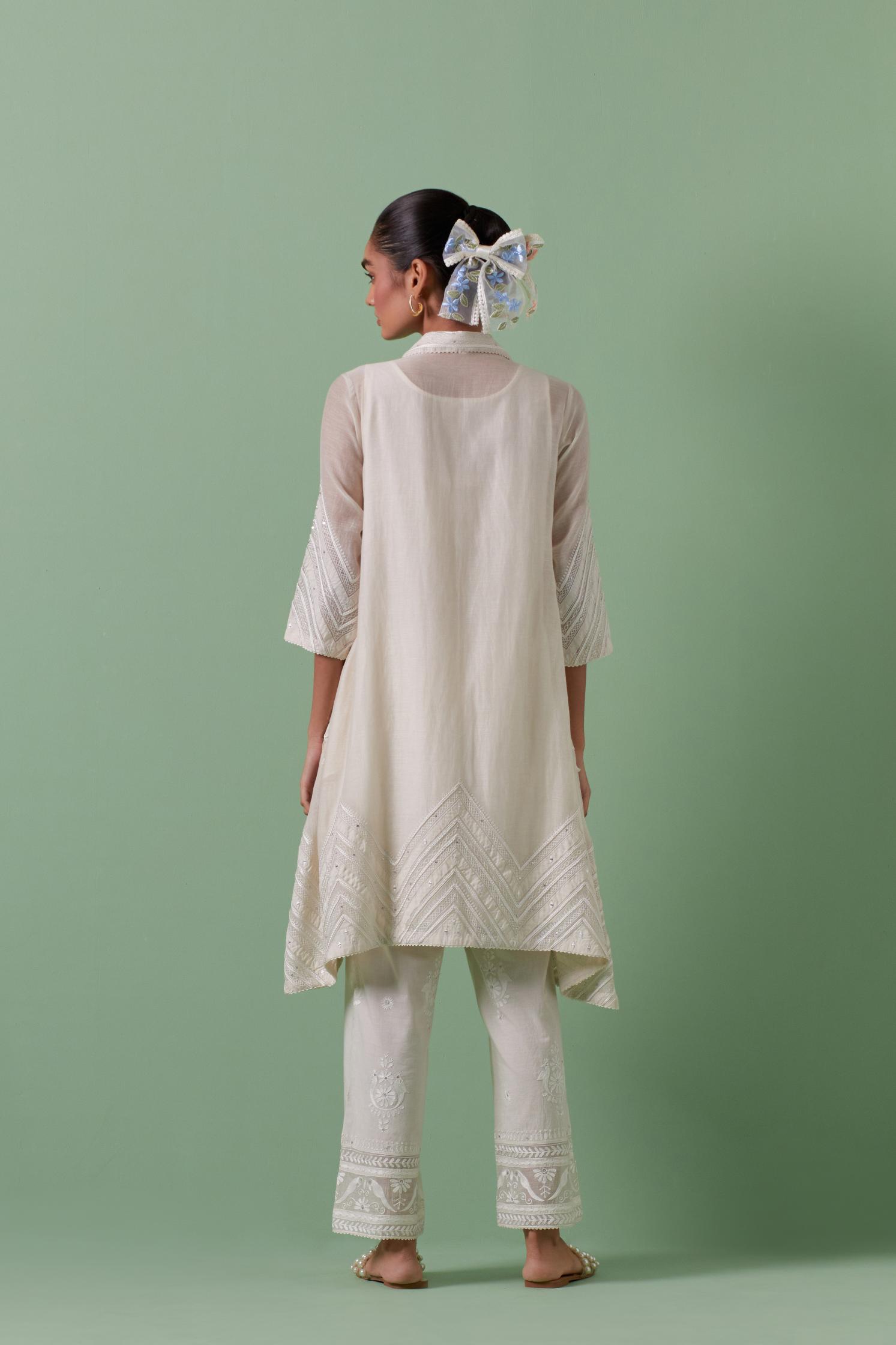 Off white cotton chanderi A-line kurta set with collar, detailed with patchwork, silk thread embroidery, mirrors, sequins and tassels.