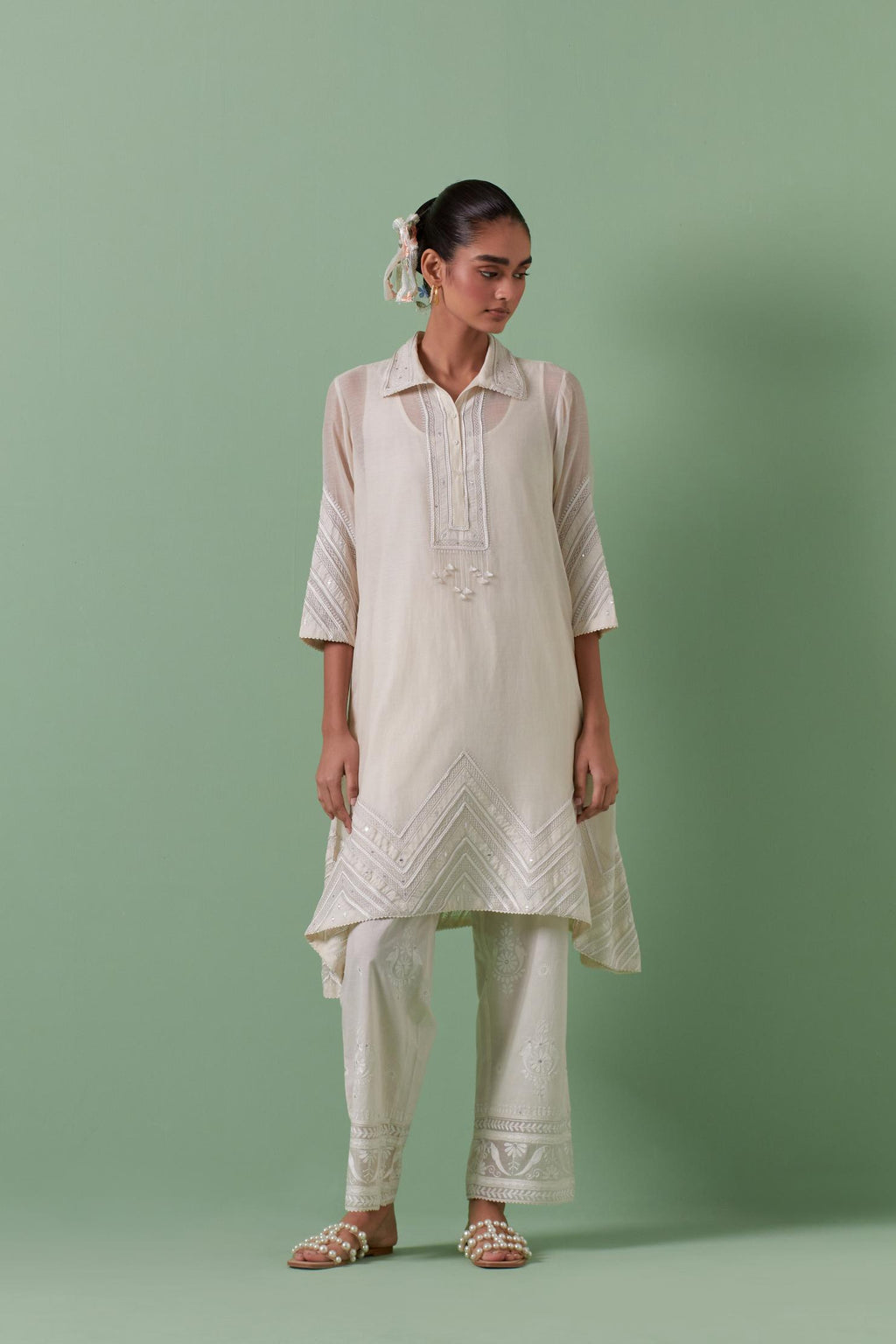 Off white cotton chanderi A-line kurta set with collar, detailed with patchwork, silk thread embroidery, mirrors, sequins and tassels.