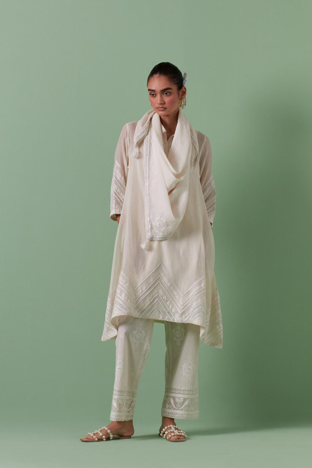 Off white cotton chanderi A-line kurta set with collar, detailed with patchwork, silk thread embroidery, mirrors, sequins and tassels.