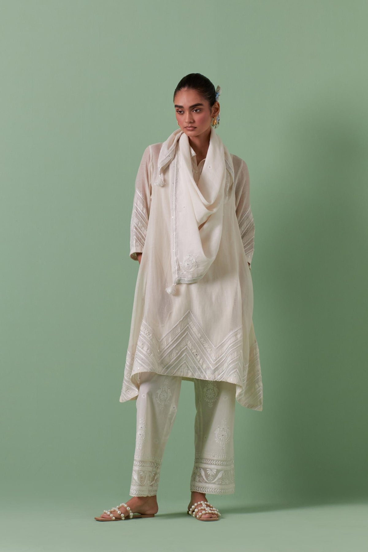 Off white cotton chanderi A-line kurta set with collar, detailed with patchwork, silk thread embroidery, mirrors, sequins and tassels.