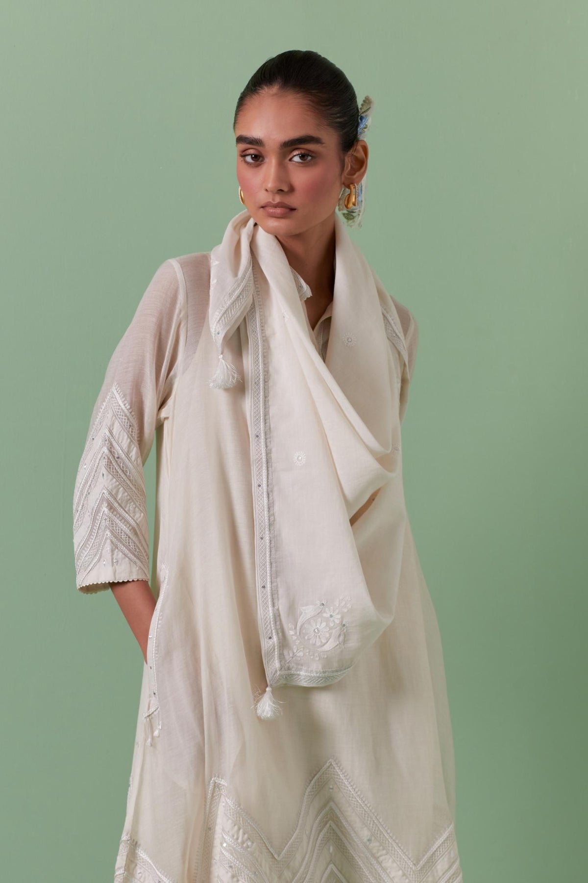 Off white cotton chanderi A-line kurta set with collar, detailed with patchwork, silk thread embroidery, mirrors, sequins and tassels.