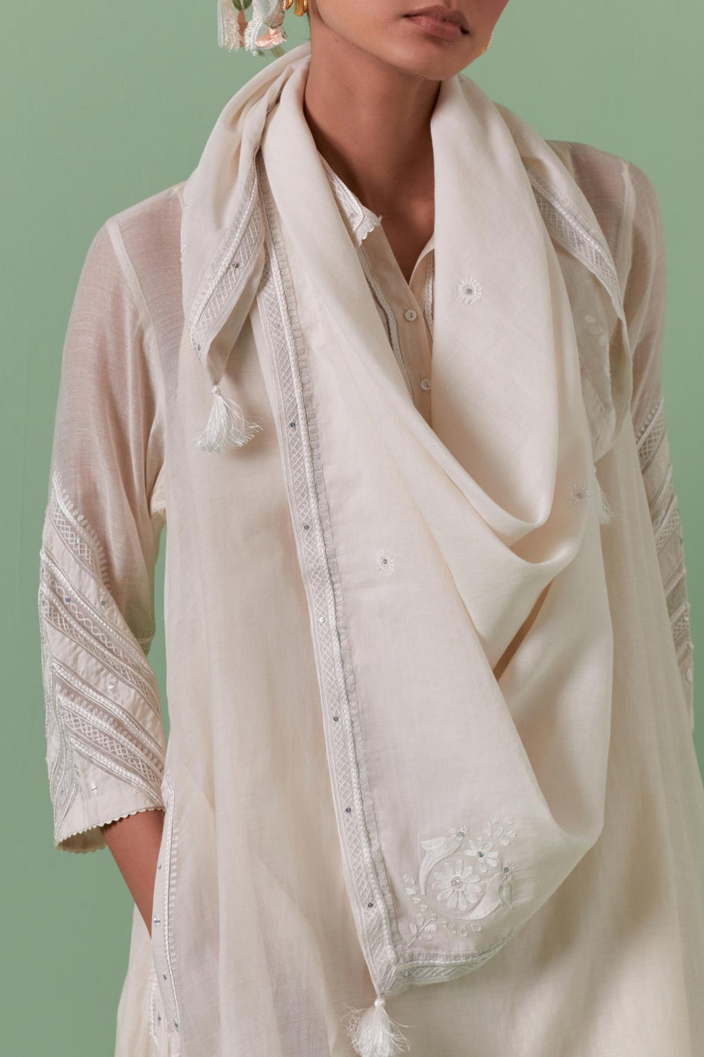 Off white cotton chanderi A-line kurta set with collar, detailed with patchwork, silk thread embroidery, mirrors, sequins and tassels.