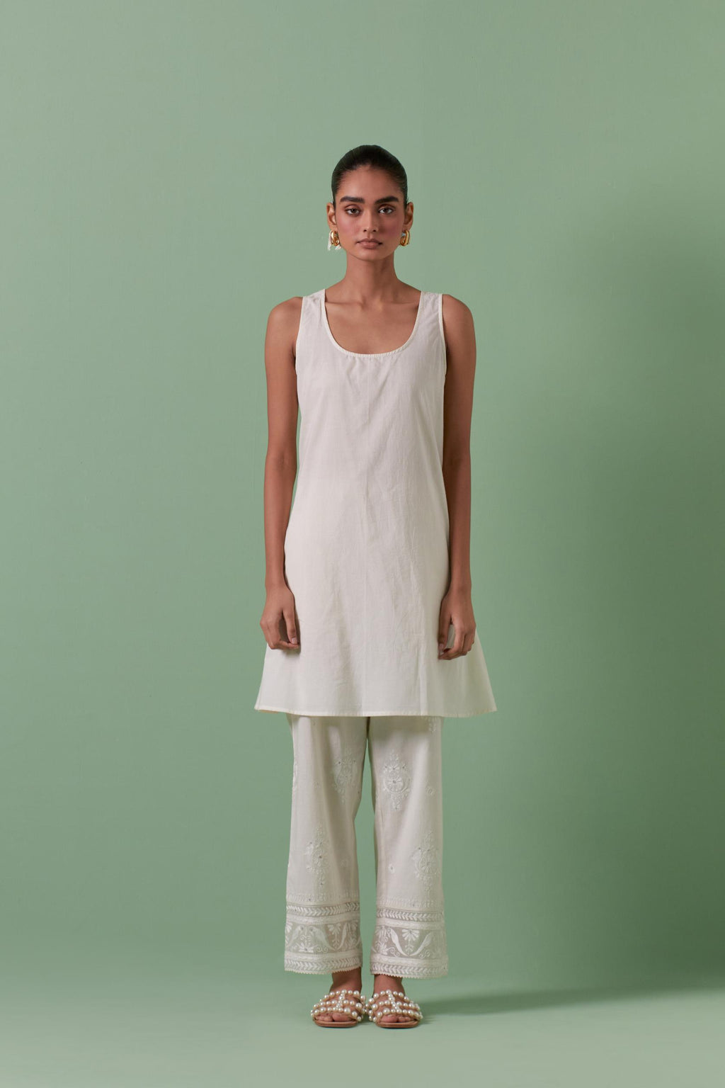 Off white cotton chanderi A-line kurta set with collar, detailed with patchwork, silk thread embroidery, mirrors, sequins and tassels.
