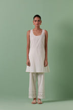 Off white cotton chanderi A-line kurta set with collar, detailed with patchwork, silk thread embroidery, mirrors, sequins and tassels.