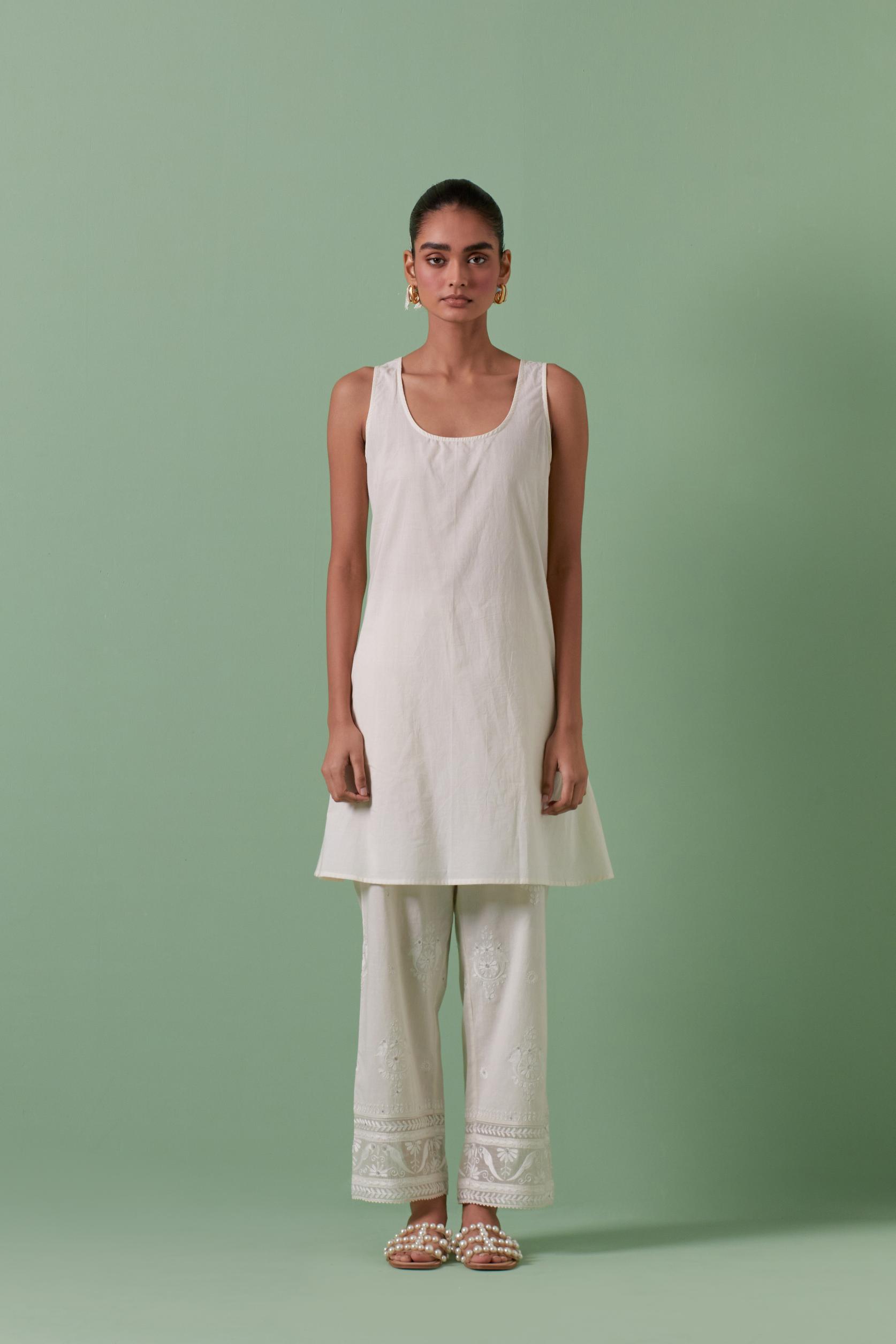 Off white cotton chanderi A-line kurta set with collar, detailed with patchwork, silk thread embroidery, mirrors, sequins and tassels.