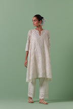 Off-white A-line cotton chanderi kurta set with all over patchwork, silk thread, mirror, tassels embroidery and sequins.
