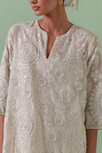 Off-white A-line cotton chanderi kurta set with all over patchwork, silk thread, mirror, tassels embroidery and sequins.