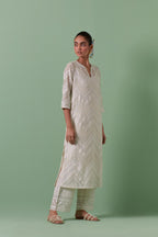 Off-white cotton chanderi straight kurta set with all over chevron pattern. It is embellished with silk patchwork, thread, sequins and mirrors.