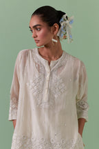 Off-white cotton chanderi embroidered short top with 3/4th sleeves, paired with off white cotton straight pants with all over off white color embroidery detailed with sequins.